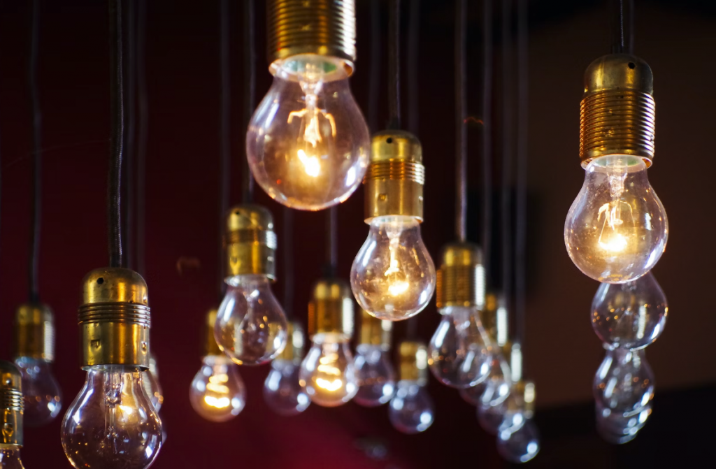 several lit light bulbs against black background